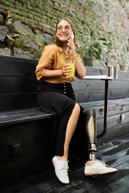 Rahat bir kafede, genç bir kadın rahatça otururken içkisini yudumluyor, neşe ve güven saçıyor..