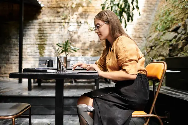 stock image In a cozy cafe, a young woman with an artistic flair works on her laptop while sipping coffee, embracing her vibrant lifestyle.