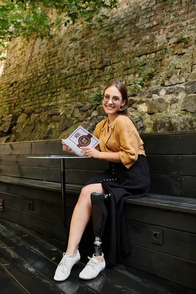 Stock image In a charming cafe, a young woman with a prosthetic leg relaxes as she reviews the menu, showcasing her vibrant lifestyle.