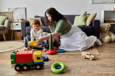 A mother and her daughter enjoy a playful moment together, surrounded by vibrant toys. clipart