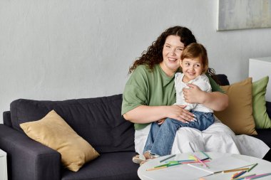 A loving mother embraces her daughter as they engage in colorful arts and crafts together. clipart