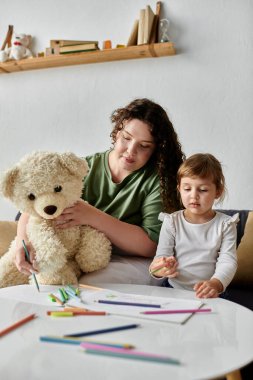 Bir anne ve kızı resim malzemeleriyle çevriliyken birlikte güzel vakit geçirir..