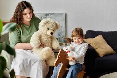 Sevgi dolu bir anne ve kızı evdeki yumuşak oyuncaklarla güzel bir anı paylaşıyor..