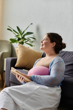 Mutlu ve cüsseli kadın ev kıyafetleri kitaplarını tutuyor, evde..