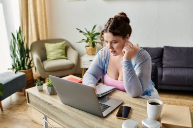 Hard working young woman in cozy homewear working from home, remote. clipart