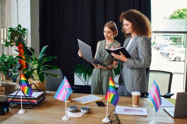 İki meslektaş, LGBTQ topluluğunun sembolleriyle çevriliyken yaratıcı bir tartışmaya giriştiler..
