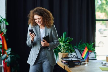 Mutlu bir birey rengarenk kapsayıcı sembollerle çevriliyken telefonuyla meşgul olur..