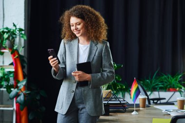 Neşeli bir ekip üyesi çalışma alanında LGBT topluluğunu temsil ederken meslektaşlarıyla meşgul oluyor.