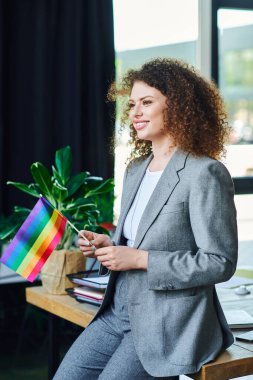 Kendine güvenen bir insan gururla gökkuşağı bayrağı sallıyor, iş yerinde LGBT topluluğunu destekliyor..