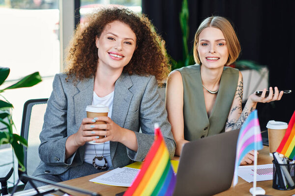 Two coworkers proudly embrace their identity while enjoying a productive day at work.