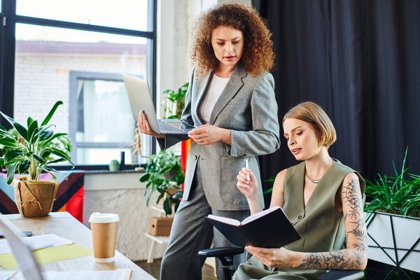 Два сотрудника ведут продуктивную дискуссию в окружении растительной жизни, способствуя инклюзивности.