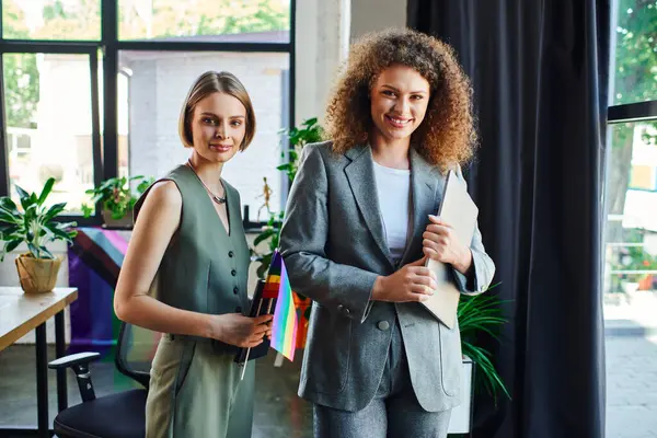 stock image Two coworkers proudly celebrating their commitment to the LGBT community in an office space.