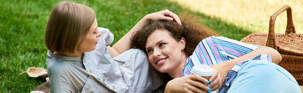 Two friends relax on a picnic blanket, sharing laughter and warm memories under the sun.