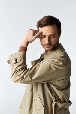 Yakışıklı bir birey şık bir poz sergiliyor, zarif giyinirken düşüncelere dalmış..