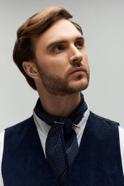 Yakışıklı adam şık bir atkı ve şık bir yelek ile zarafetini sergiliyor..