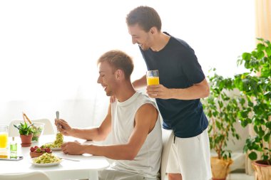 Modern mutfaklarında yemek yiyen sevgi dolu bir çift.