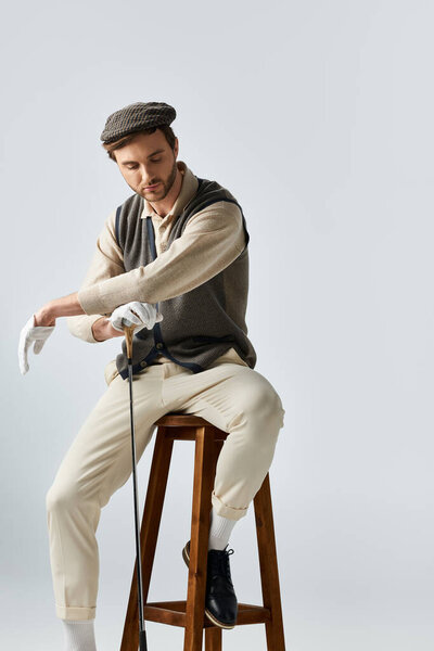 A handsome stylish man prepares himself, showcasing a blend of vintage fashion and charm.