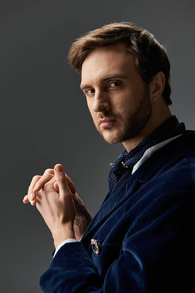 Стильный человек с уверенным выражением лица демонстрирует свою стильную моду в драматической атмосфере.