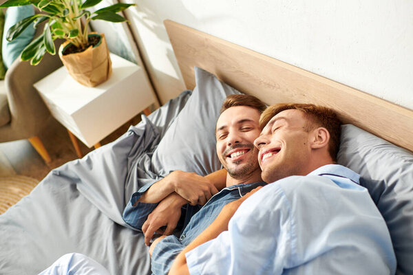 Радостное утро раскладывается, как гей-пара сидит в пижаме, делясь любовью и теплом в постели.