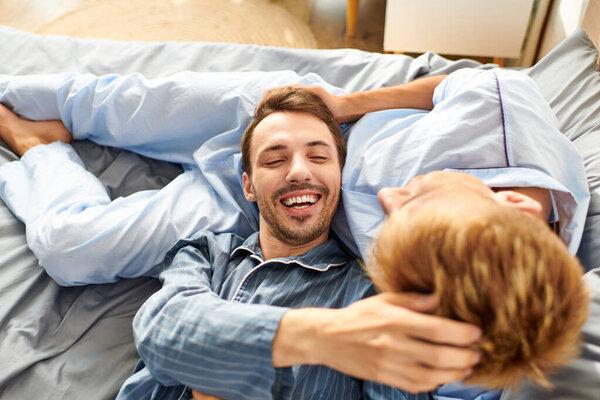 Счастливое утро разворачивается, как любящая гей-пара расслабляется в пижаме, обнимаясь и наслаждаясь своим временем вместе.