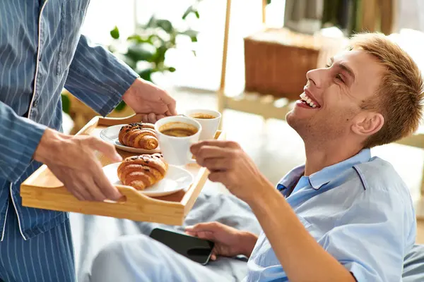 stock image A joyful morning unfolds as a loving couple enjoys breakfast together while lounging in their pajamas.