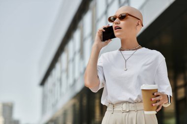 Genç kel bir kadın dışarıda şık bir ortamda kahve içip sohbet ediyor..