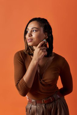 Tarz sahibi genç bir kadın, özgün tarzını sergileyerek, parlak ve dinamik bir stüdyo atmosferine dikkatle yansıtır..