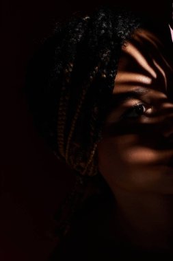 Kendine güvenen genç bir kadın şık bir stüdyo ortamında göze çarpar..