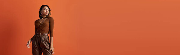 Молодая афроамериканка демонстрирует свой смелый стиль, выставляя уверенную позу в студии..