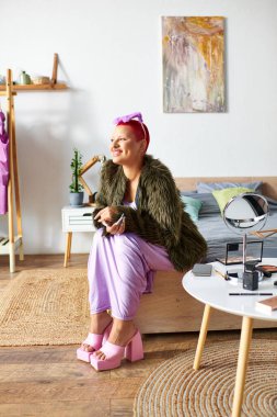 Genç bir kadın evinde rahat bir şekilde oturmuş renkli moda anlayışını ve bireyselliğini ifade ediyor..