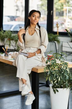 Profesyonel bir genç kadın, çağdaş ofis çalışma alanında düşünceli görevler üstlenir..