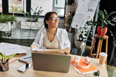 Davetkar bir ofis ortamında genç bir profesyonel, işine bağlanıyor, neşe saçıyor..