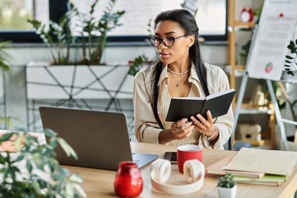 В ярком офисе, наполненном зеленью, сфокусированная женщина пишет в блокноте во время работы.