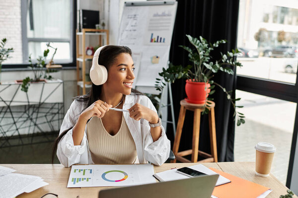 In a bright office, a young woman smiles while brainstorming ideas and analyzing data.