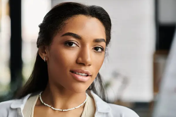 stock image A young, beautiful woman focuses intently while working in a stylish office environment.