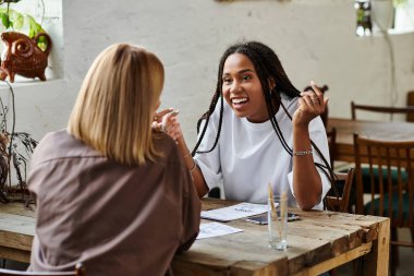 Neşeli bir çift, sıcaklıkla dolu bir kafede kahve içerken bir anlık yakınlık paylaşıyor..