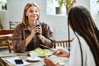 A vibrant couple shares laughter and memories over brunch in a stylish cafe filled with sunlight. clipart