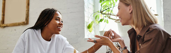 Радостный момент разворачивается, как улыбающаяся женщина с плетеными волосами наслаждается временем со своей девушкой в кафе.