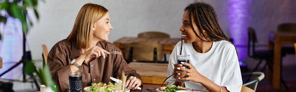 Радостный момент разворачивается, когда улыбающаяся женщина разделяет трапезу со своей девушкой в уютном кафе.