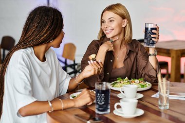 Canlı, çok kültürlü bir çift bir kafede hafif bir yemek ve kahkaha içerken birbirlerine eşlik etmekten zevk alır..