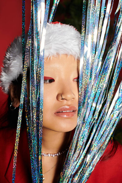 An Asian woman captivates with her vibrant gaze and festive decorations.