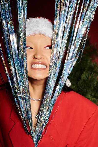 stock image A joyful Asian woman in vibrant festive attire stands among sparkling decorations.