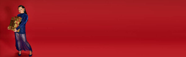 Прекрасная женщина показывает праздничные подарки, демонстрируя свою сдержанность и стиль в поразительной обстановке.