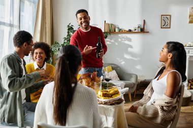 A group of friends gathers at home, sharing laughter and a festive Thanksgiving meal together. clipart