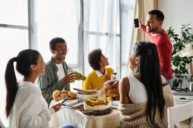 Bir grup arkadaş, yemek, neşe ve sohbetle dolu bir Şükran Günü yemeğini paylaşıyor..