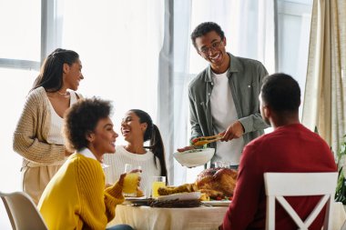 Bir grup arkadaş Şükran Günü 'nü kutluyor. Sıcak bir evde yemek yiyip gülüyorlar..