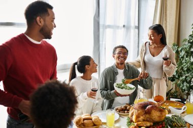 Bir grup arkadaş birlikte sıcak bir Şükran Günü yemeği yer, yemek ve kahkaha atarız..