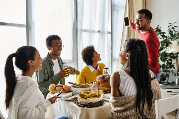 Группа друзей делится праздничной трапезой на День Благодарения, наполненной едой, радостью и беседой..