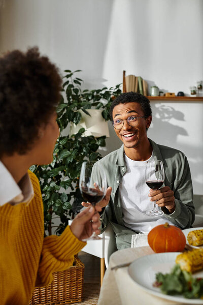 Группа друзей разделяет праздничную трапезу в честь Дня Благодарения, наполненную радостью и теплой беседой.