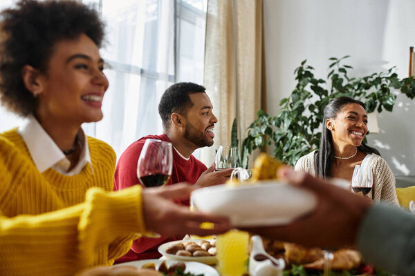 Близкие друзья наслаждаются Днем Благодарения вместе, делятся историями, смехом и сытной едой дома.